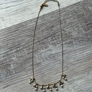 Dainty gold and cream beaded necklace with a touch of whimsy